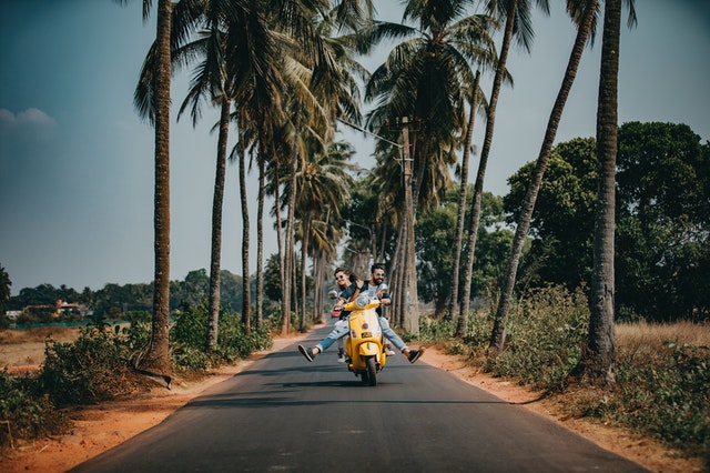 woman and man riding motorcycle, is travel insurance worth it