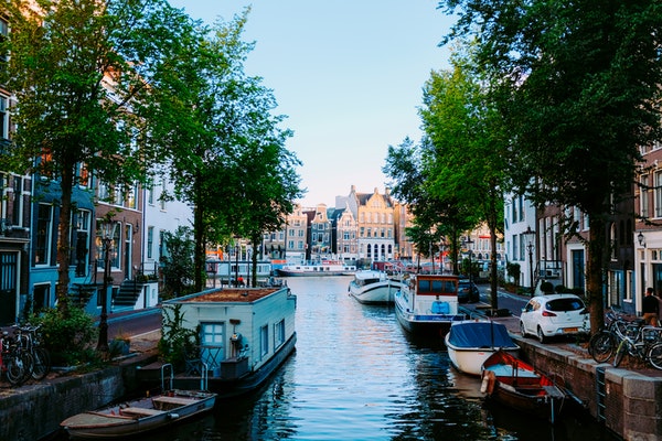 canal hugged by buildings on either side in amsterdam the netherlands