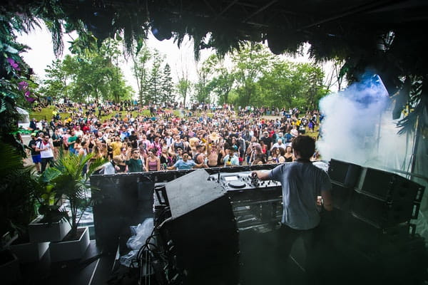 dj in front of music festival crowd 