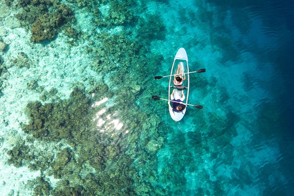 kayakers floating in clear water in the maldives