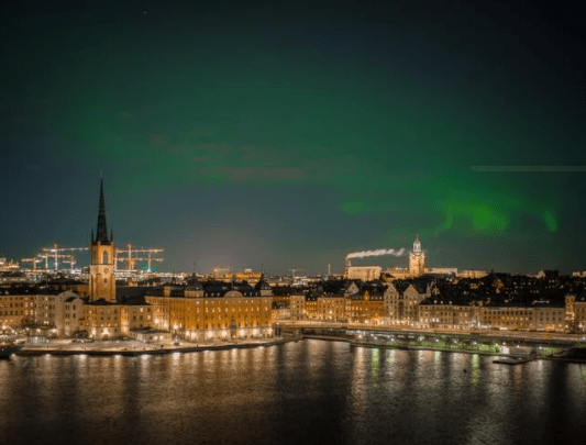 night view of city in sweden with aurora sky