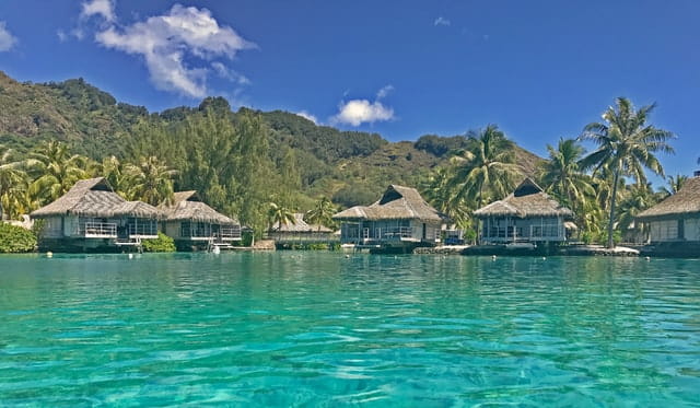 overwater bungalows in bora-bora french polynesia in front of mountains