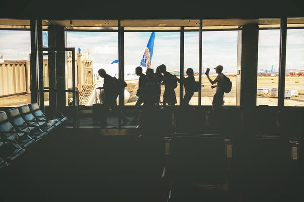 people walking past a window at the airport