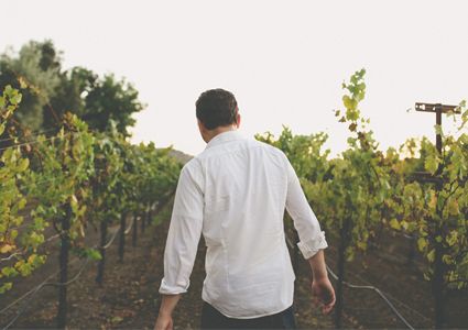 young man walking through vineyard