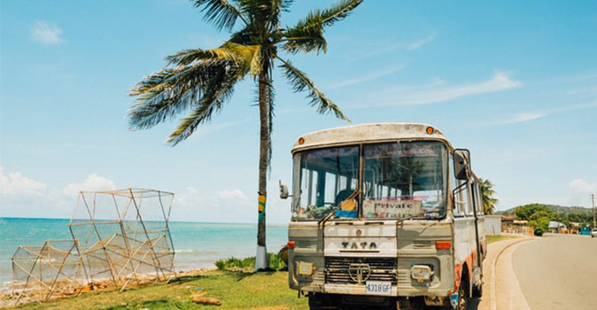 tour bus for Jamaica travel parked beside ocean; travel to jamaica; jamaica travel restrictions