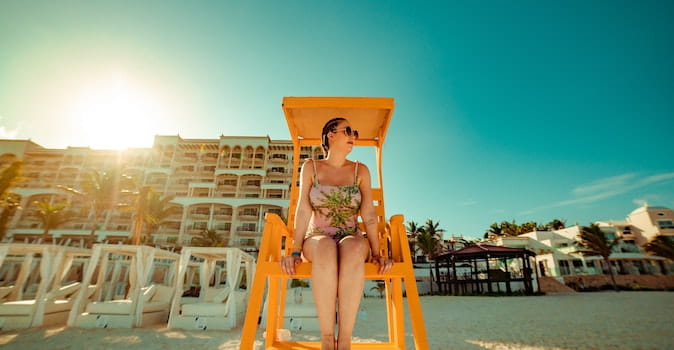 travel insurance for mexico featured image of woman in orange chair on cancun beach