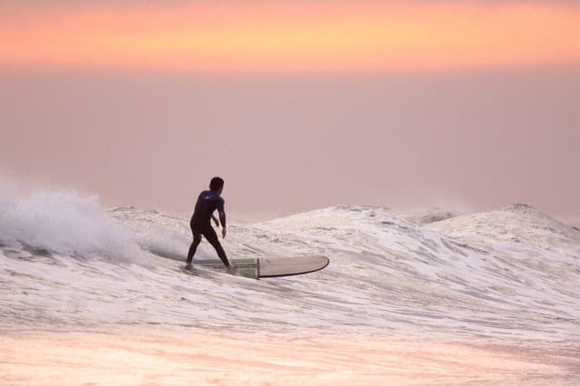 man surfing at golden hour