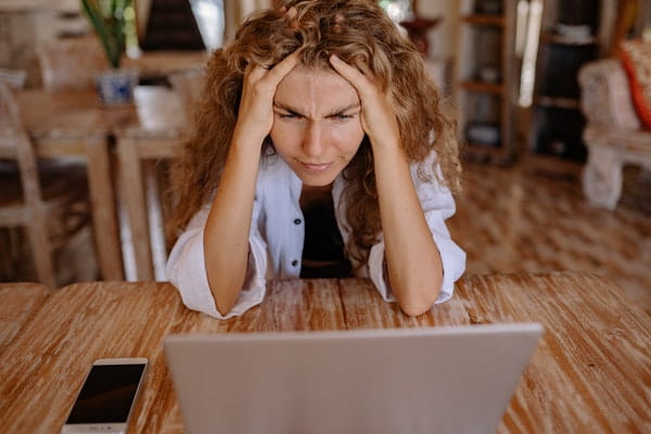 woman leaning over wooden table looking stressed