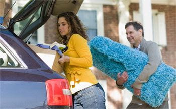 Young girl unpacking car, moving home after college