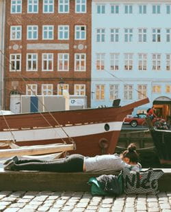 study abroad student napping on boat dock in denmark