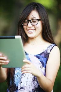 Girl Smiling at Her Tablet