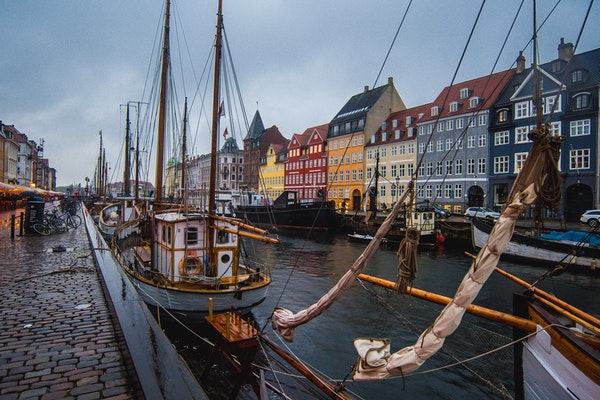 docked boats and colorful buildings along the water in copenhagen denmark
