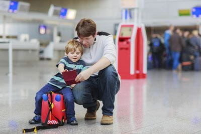 father and son with passport in airport