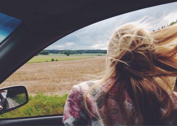 woman enjoying road trip with windows down