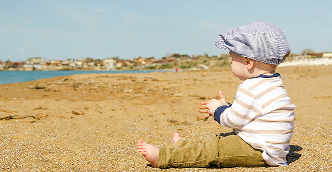 toddler-sitting-on-beach-toddler-travel-checklist