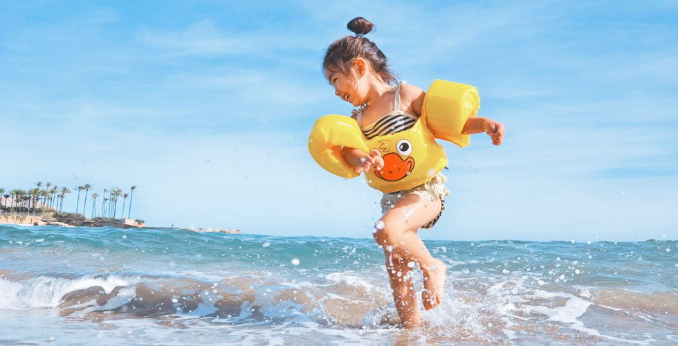 little-girl-in-floaties-playing-in-the-ocean