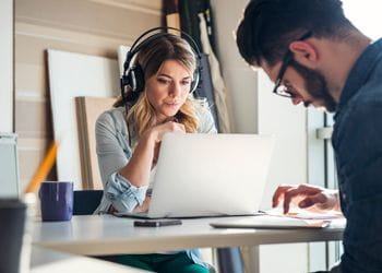 woman-on-laptop-listening-to-music-in-headphonesjpg
