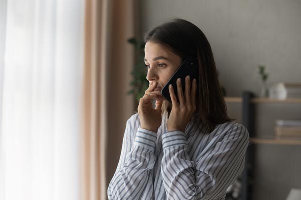 sad-millennial-woman-has-difficult-phone-talk-hold-gadget-by