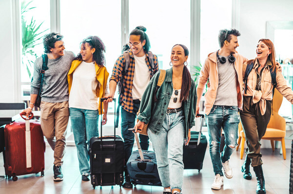 young-group-of-tourists-with-suitcases-arriving-at-youth-hostel