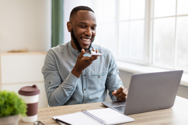 african-businessman-with-smartphone-using-voice-assistant-app-or-loudspeaker african-businessman-with-smartphone-using-voice-assistant-app-or-loudspeaker