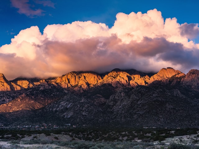 pink cloud sitting above mountains near albuquerque